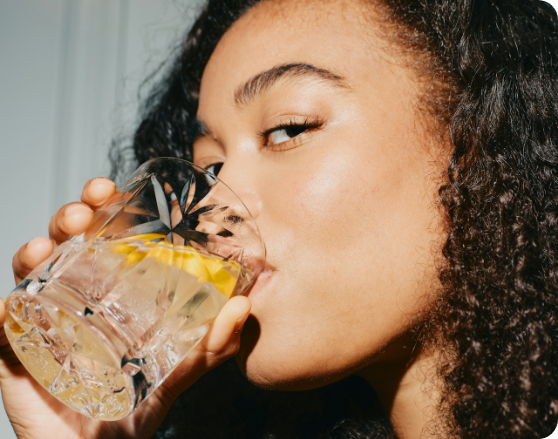 A woman sipping an Altrd Bliss mocktail